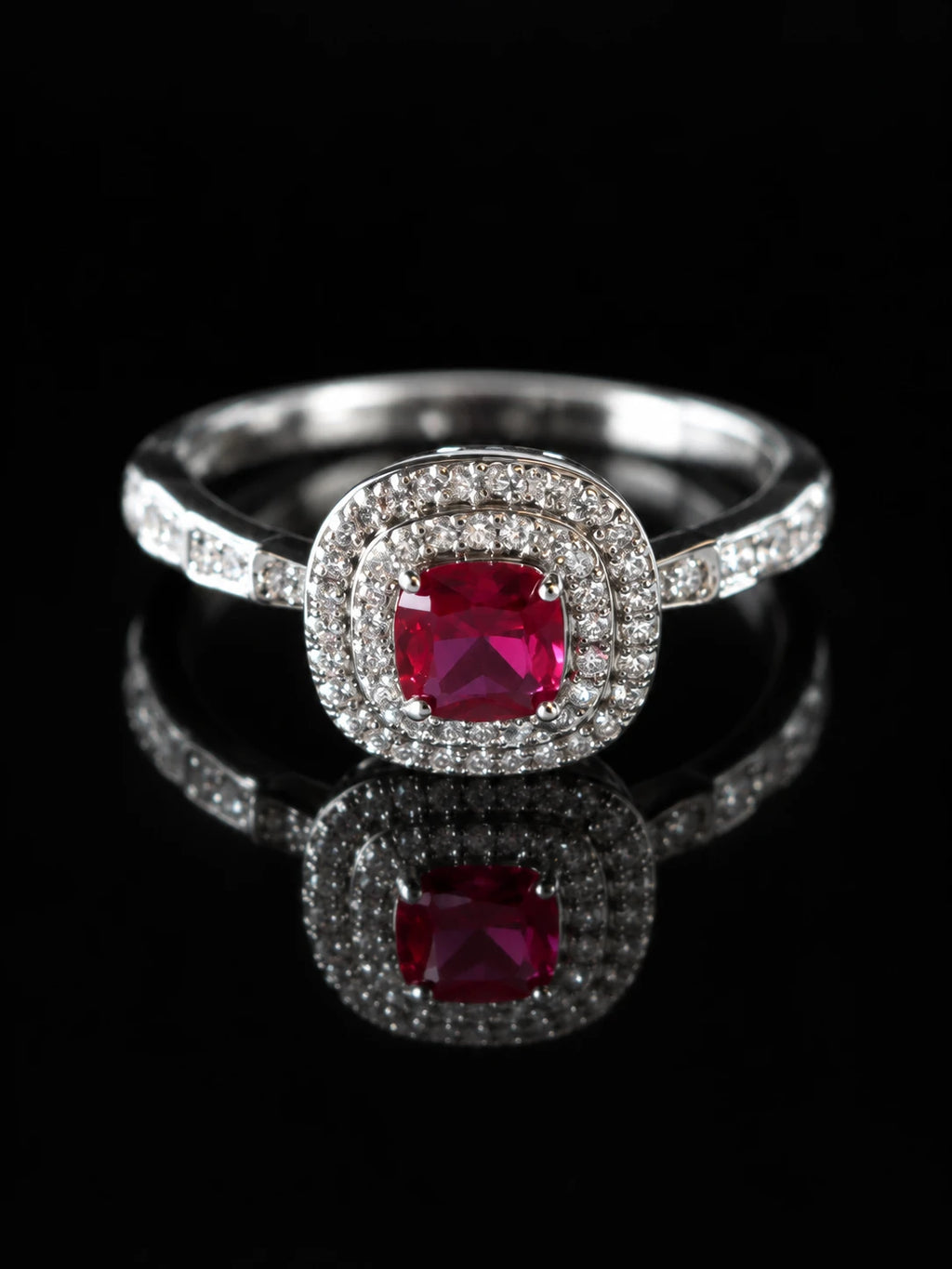 Silver Ruby-Red CZ Cushion Halo Ring on a black background