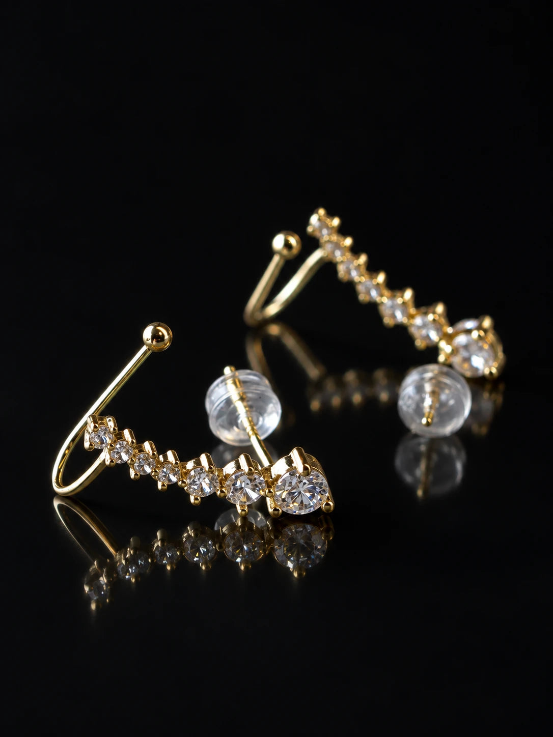 Gold Starline Ear Climbers on a black background