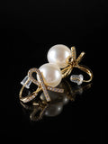 Gold Pearl Bow Studs on a black background