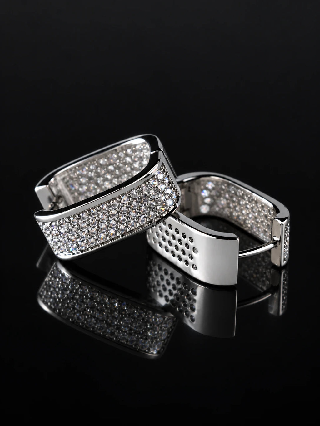 Silver Wide Pave Huggies on a black background