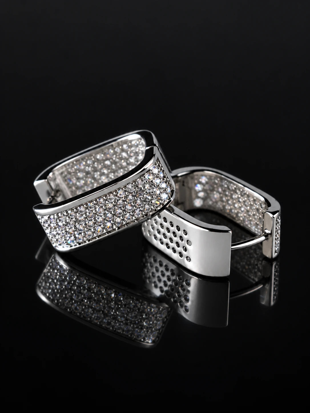 Silver Wide Pave Huggies on a black background
