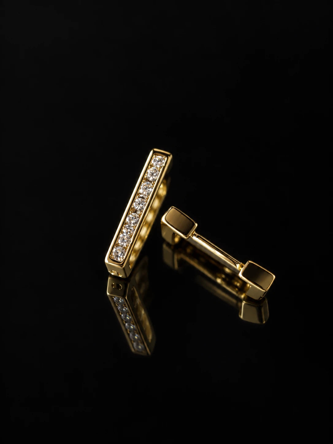 Gold Linear Pavé Huggies on a black background