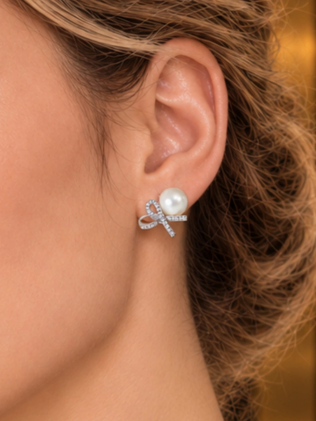 Alternate close-up of Silver Pearl Bow Studs being worn