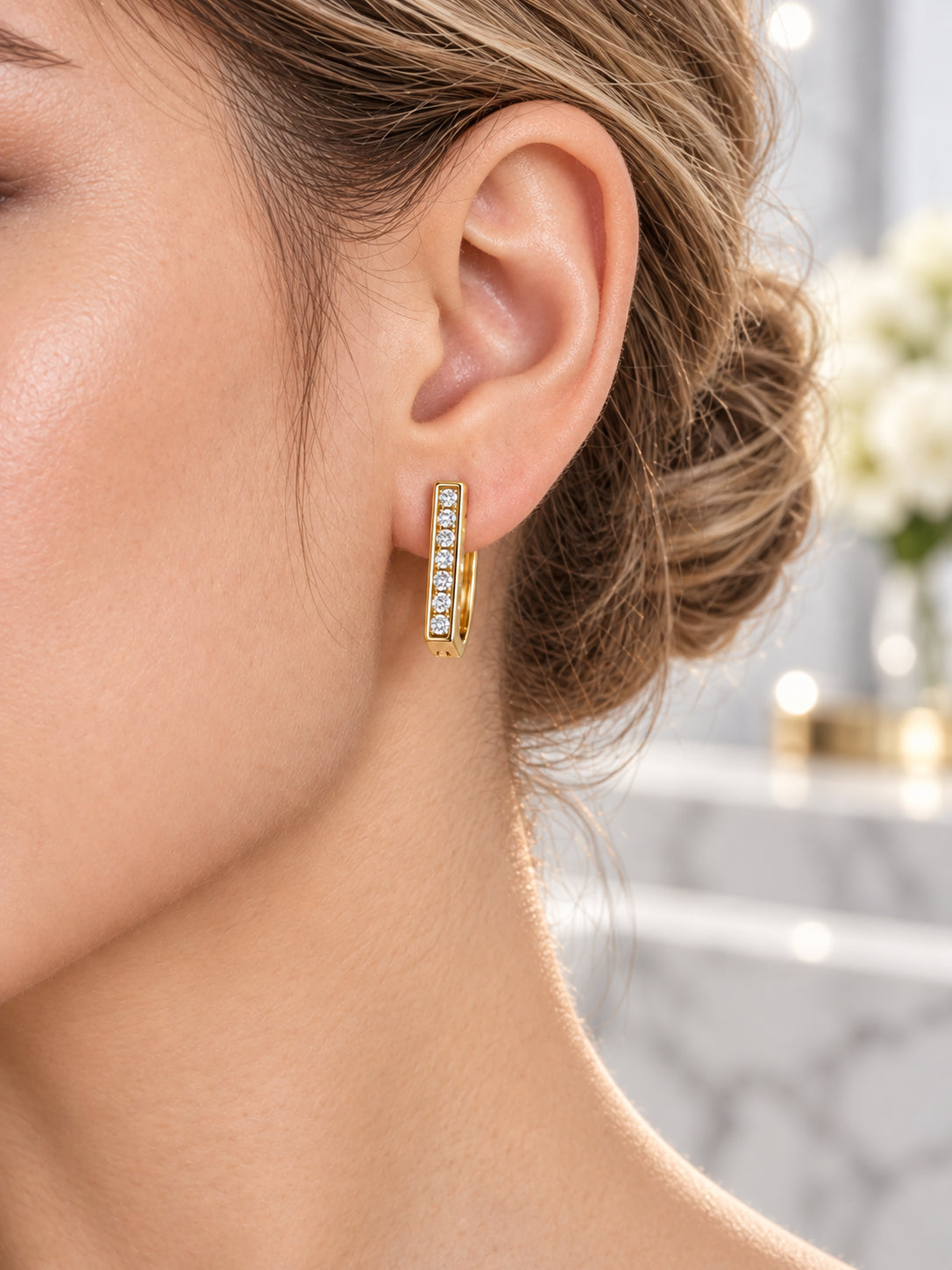 Close-up of Gold Linear Pavé Huggies being worn