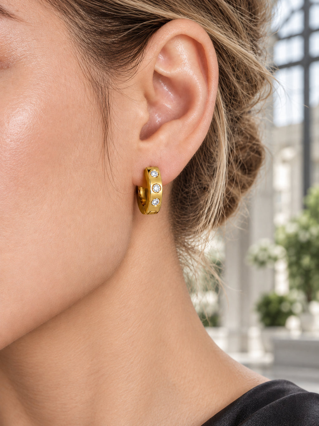 Close-up of Gold Dot CZ Huggies being worn