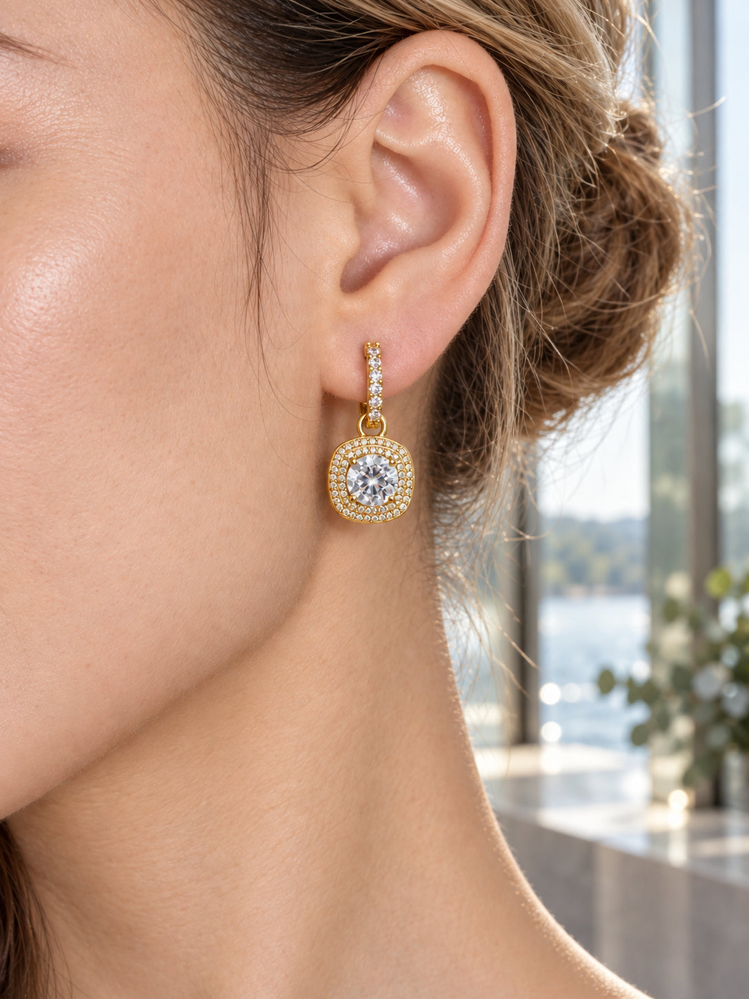 Close-up of Gold Cushion Halo Drop Hoops being worn