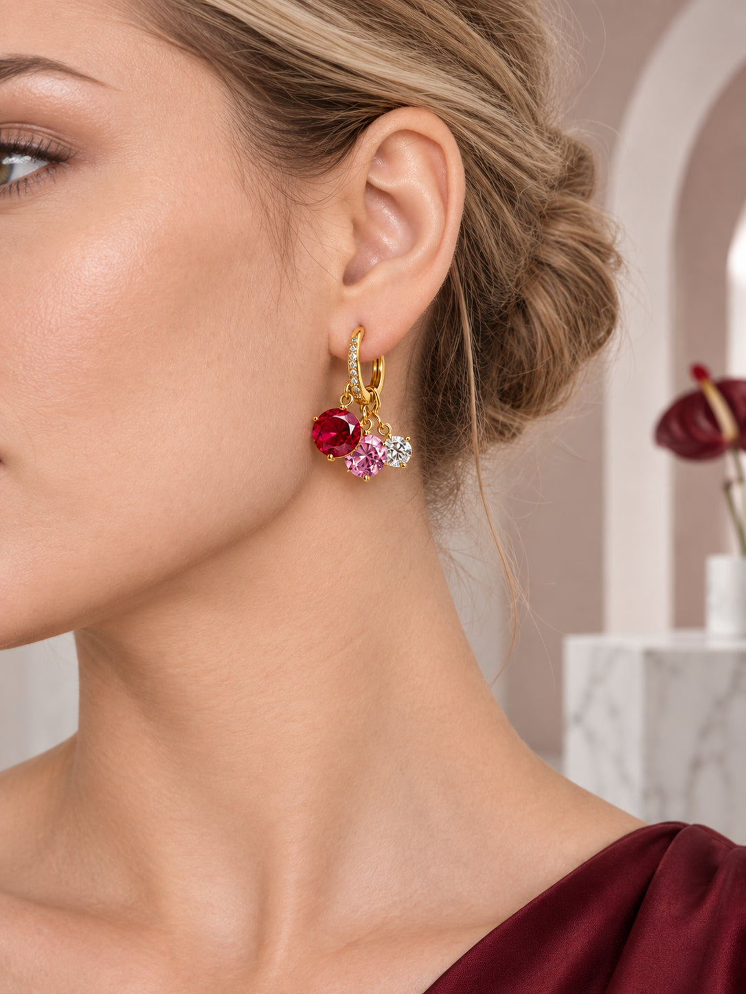 Close-up of Gold Ruby Charm Hoops being worn